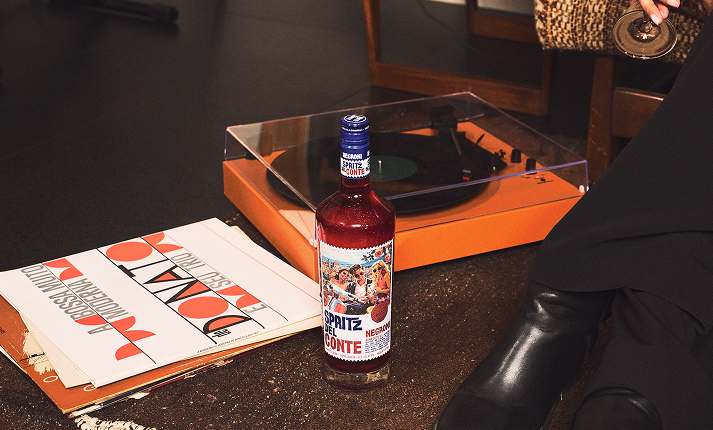 A bottle of Negroni Spritz alongside a record player.