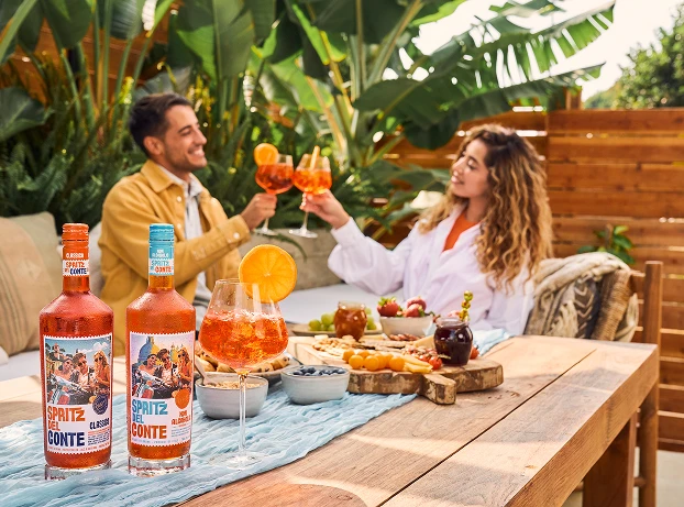 Two people enjoying Classico Non-Alcoholic at a garden party