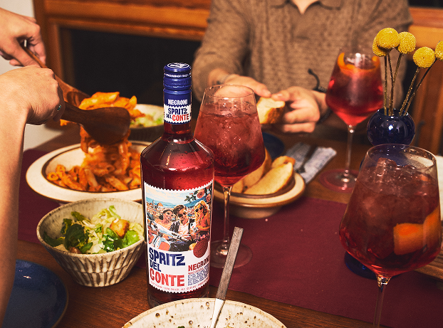 A bottle of Spritz Del Conte Negroni alongside a dinner party spread